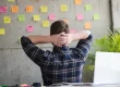 entrepreneur staring at post-it notes on concrete wall